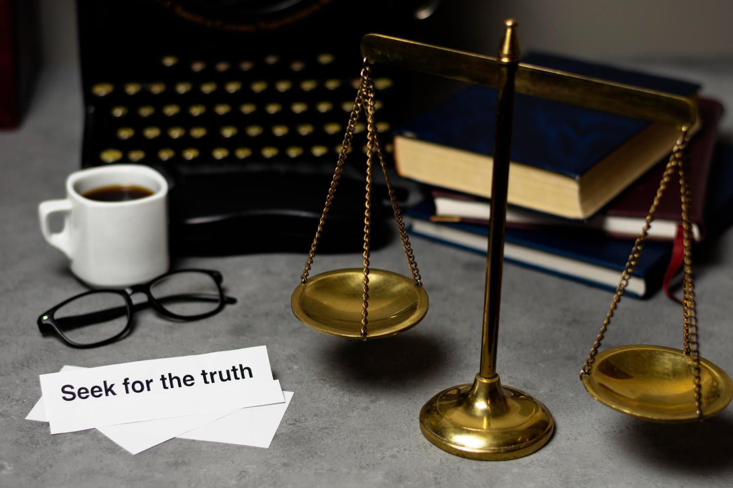Scales of justice on a lawyer’s desk with law books, glasses, and paperwork, symbolising accuracy, compliance, and financial balance in law firm bookkeeping. 