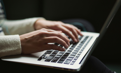 A person typing on a laptop computer