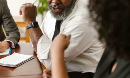 Colleagues discussing documents at an office meeting; illustrative stock photo
