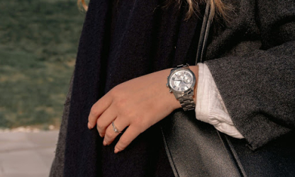 Close-up of a person wearing a classic wristwatch and ring, symbolising timeless accessories and understated professional style.