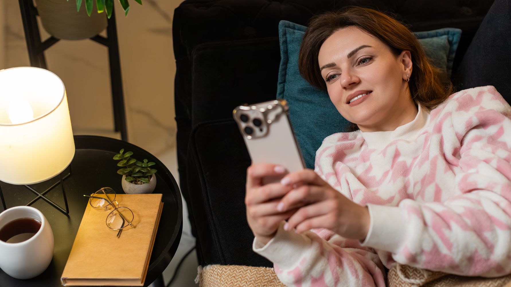 Woman sitting on a sofa using her phone at home
